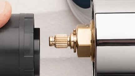 Close-up of a plumbing valve being attached to a pipe.